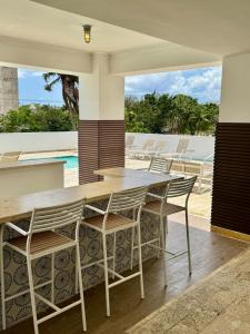 a table and chairs on a patio with a pool at JUAN DOLIO 2BR Beach front SALITRE across Club Hemingway in Juan Dolio