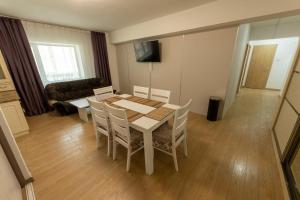 a dining room with a table and chairs and a couch at BNM Base Camp - Ulaanbaatar in Ulaanbaatar