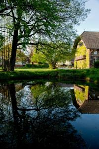 eine Spiegelung eines Gebäudes in einem Gewässer in der Unterkunft Der Linslerhof - Hotel, Restaurant, Events & Natur in Überherrn + 69 Fotos