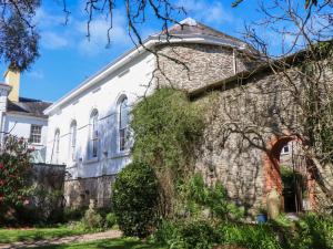 an old stone house with a stone wall at The Music Room in Aveton Gifford