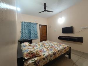 a bedroom with a bed and a flat screen tv at Gokula Arcade in Subrahmanya
