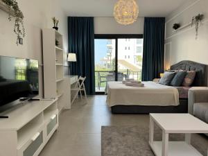 a living room with a bed and a television at Caesar Blue Collection Nothern Cyprus Studios & Spa Resort in Kaimakli