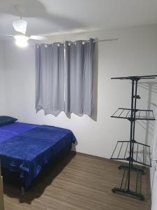 a bedroom with a bed with a blue comforter at Apto Térreo Próximo HU e Aeroporto Vaga e Ar in Londrina
