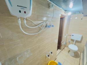 a bathroom with a white toilet and a shower at Mysore rooms- sgh in Mysore