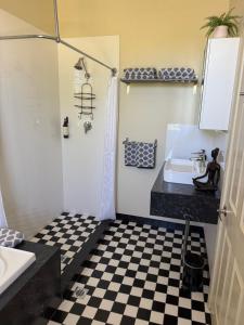 a bathroom with a black and white checkered floor at Lotte's Cottage in Broken Hill
