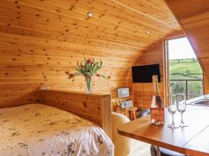 a bedroom with a bed and a table with wine glasses at The Rhiw in Newtown