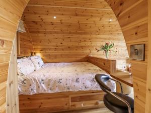 a bedroom with a bed in a wooden cabin at The Rhiw in Newtown