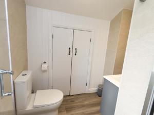 a white bathroom with a toilet and a sink at High Dow Crag in Coniston +14 photos