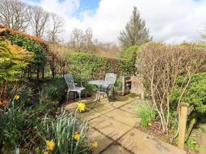 a patio with two chairs and a table in a garden at High Dow Crag in Coniston