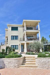 a large white building with stairs in front of it at Villa Valeria in Rogoznica