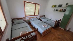 a room with three beds and a window at ILIS House Matka Canyon in Skopje