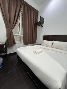 a bedroom with a white bed with a window at Hotel O Friend in Petaling Jaya