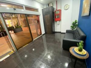 a lobby with a couch and a table and a clock at Hotel O Friend in Petaling Jaya