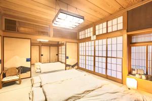 a bedroom with a large bed in a room with windows at Jokan-en in Honjo