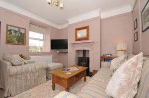 a living room with two couches and a fireplace at Tor View Fourwinds in Okehampton
