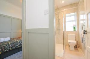 a bathroom with a shower and a toilet and a bed at Tor View Fourwinds in Okehampton +21 photos