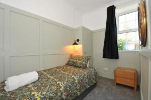 a small bedroom with a bed and a window at Tor View Fourwinds in Okehampton