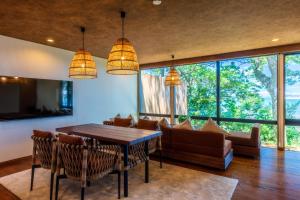 a living room with a table and chairs and windows at Ishinoya Beppu - TKP Hotels & Resorts in Beppu