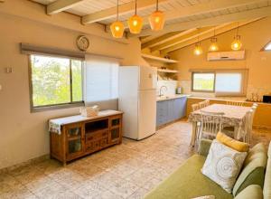 a kitchen with a couch and a table and a refrigerator at נוף הרים בר יוחאי - בית נופש מדהים עם בריכה וג'קוזי in Bar Yohai