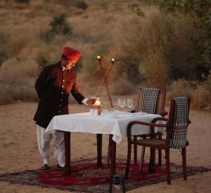 a man standing in front of a table with a candle at Desert Horizon Luxury Resort &Camp in Jaisalmer