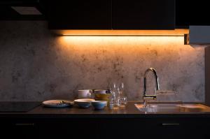 a kitchen counter with a sink and plates and glasses at monel in Nakafurano
