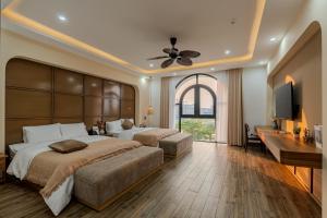 a bedroom with two beds and a flat screen tv at Mana Hotel Quảng Bình in Dong Hoi +134 photos