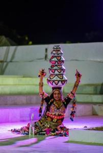 a woman sitting on the ground with a pagoda on her head at Desert Horizon Luxury Resort &Camp in Jaisalmer