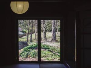 a window in a room looking out at a forest at ノキシタ in Hokuto