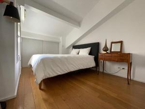 a bedroom with a bed and a table with a mirror at Elegant Marseille Prado Loft Walk to velodrome metro and Tram in Marseille