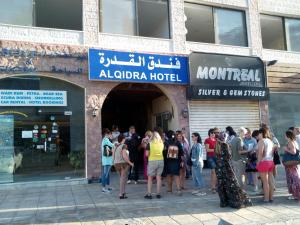 eine Gruppe von Personen, die außerhalb eines Gebäudes stehen in der Unterkunft Al Qidra Hotel & Suites Aqaba in Aqaba