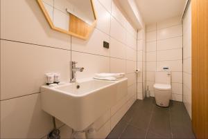 La salle de bains blanche est pourvue d'un lavabo et de toilettes. dans l'établissement Blue Hills Motel, à Hobart