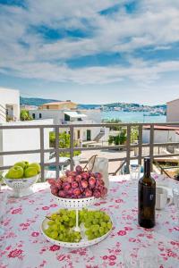 a table with two bowls of fruit and a bottle of wine at Villa Valeria in Rogoznica