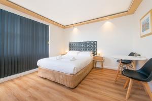 Schlafzimmer mit einem Bett, einem Tisch und Stühlen in der Unterkunft Blue Hills Motel in Hobart