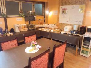 a dining room with a table with flowers on it at Hotel Matsumoto Hills in Matsumoto
