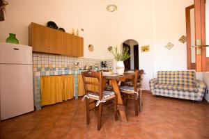 スコペッロにあるVilla Chiaraのキッチン(テーブル、椅子、冷蔵庫付)