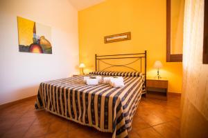 1 dormitorio con 1 cama con colcha a rayas en Villa Chiara, en Scopello