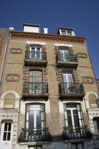 a tall brick building with windows and balconies at Simple Asile in Mers-les-Bains