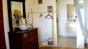 a room with a wooden dresser and a mirror at Le Logis du Rocher in Saint-Marcet +52 photos