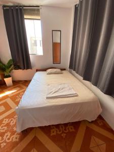 ein Schlafzimmer mit einem großen Bett vor einem Fenster in der Unterkunft GoodWaves Surf Hostel in Huanchaco