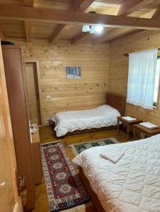 a bedroom with two beds in a log cabin at Eco Camping Valbone in Valbonë