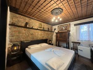 a bedroom with a bed and a brick wall at Vila Darla in Berat