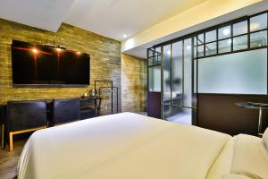 a bedroom with a bed and a tv on a brick wall at stay호텔 in Soyŏm-do