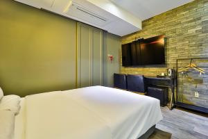 a bedroom with a white bed and a flat screen tv at stay호텔 in Soyŏm-do