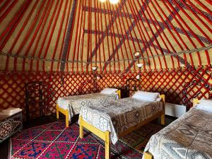 a room with three beds in a yurt at BarBulak Yurt Lodge in Bar-Bulak