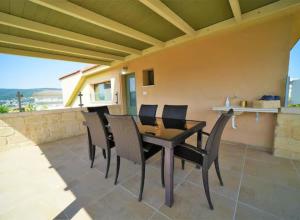 a patio with a table and chairs on a balcony at נוף הרים בר יוחאי - בית נופש מדהים עם בריכה וג'קוזי in Bar Yohai +5 photos