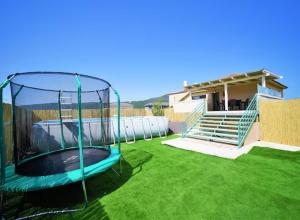 an empty trampoline in a yard next to a house at נוף הרים בר יוחאי - בית נופש מדהים עם בריכה וג'קוזי in Bar Yohai