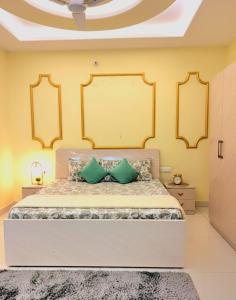 a bedroom with a large bed with green pillows at TT Homes Private Studio Suites Jaipur Pink City in Jaipur