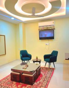 a waiting room with two chairs and a tv at TT Homes Private Studio Suites Jaipur Pink City in Jaipur