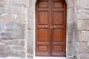 a brown wooden door in a stone wall at Ali apartments in Pizzo