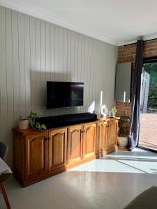 a living room with a television on a wooden cabinet at Mountain View Blue Mountains in Kurrajong